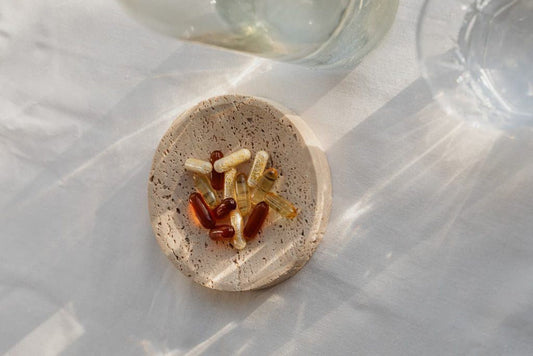 Suplementos em cápsulas sobre prato de cerâmica