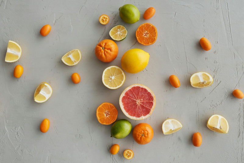 Variedade de frutas cítricas sobre fundo cinza