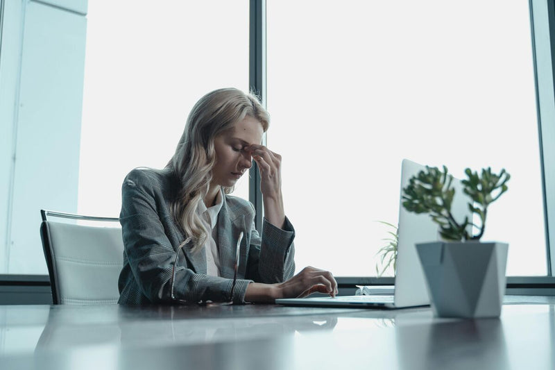 Mulher estressada trabalhando em escritório moderno.