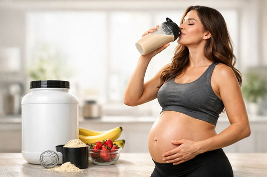 Mulher grávida bebendo shake de proteína na cozinha