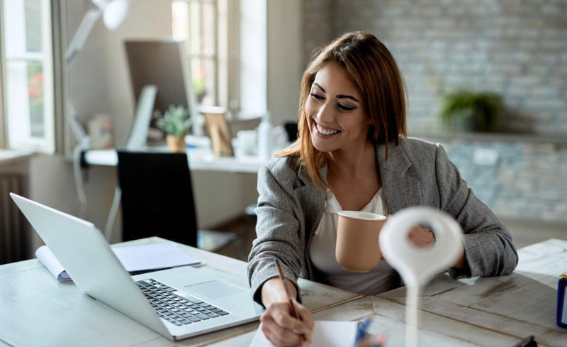 Mulher sorridente trabalhando em escritório moderno.